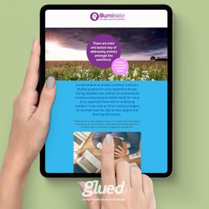 A tablet showcases a webpage titled illuminate against a serene field backdrop, discussing anxiety management in the workforce. A hand touches the screen, while the logo of Branding agency Warwickshire, Glued Limited, subtly anchors the display at the bottom.