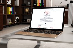 A gold laptop displaying a webpage from Glued Limited stands on a sleek, modern desk. In the background are shelves filled with books, boxes, and decor items, adding a professional yet cozy ambiance to this Marketing Agency Warwickshire office.